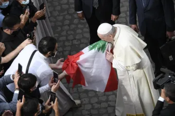 Pope Francis kisses the flag of Lebanon at his general audience on Sept. 2, 2020.